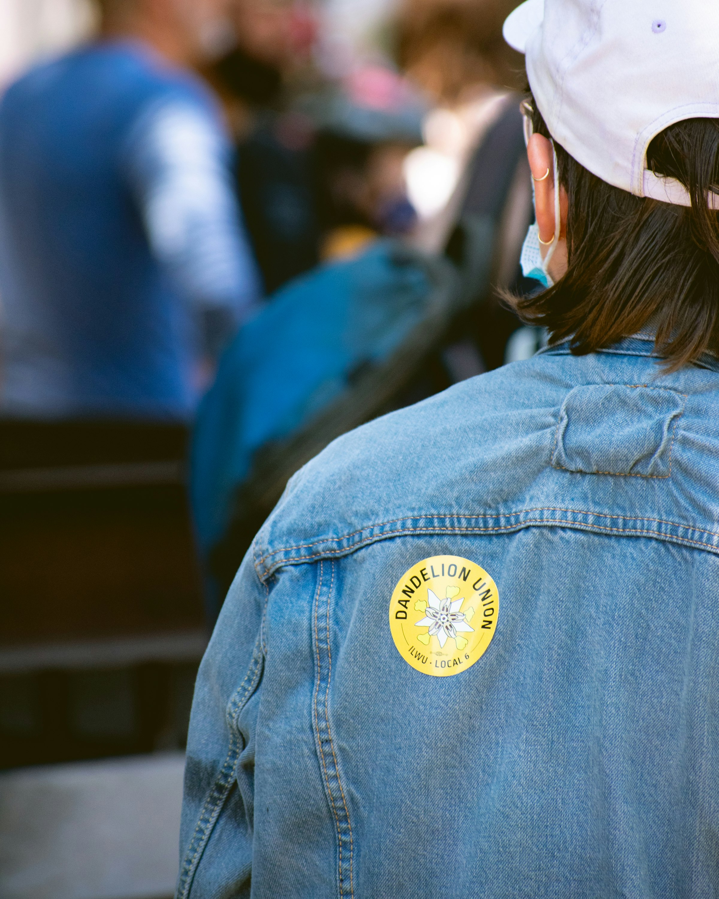 woman in blue denim jacket wearing white cap